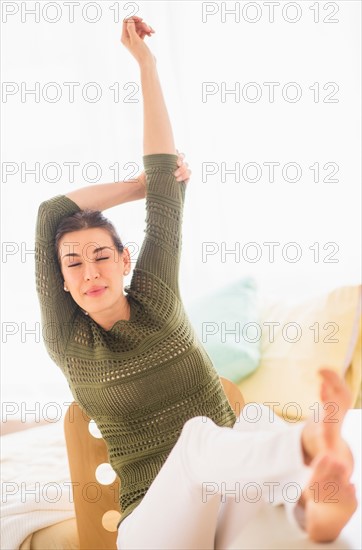 Woman with feet up and raised arms