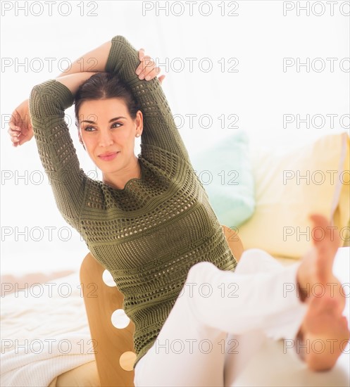 Woman with feet up and hands behind head