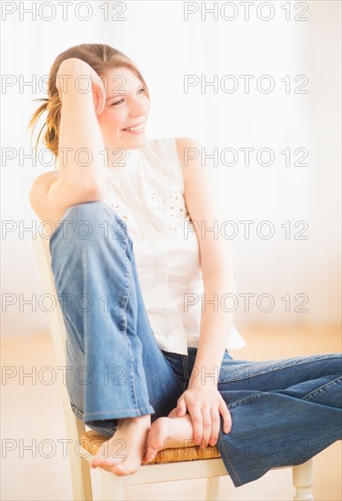 Young cheerful woman sitting on chair