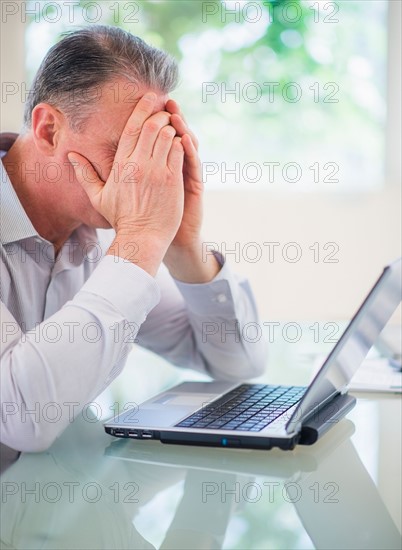 Portrait of tired man working on laptop