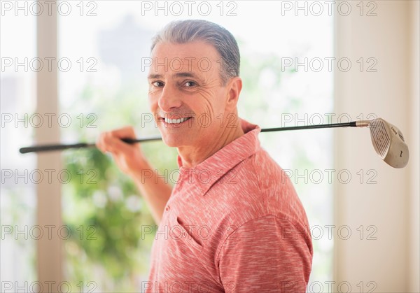 Portrait of man holding golf club on his shoulder