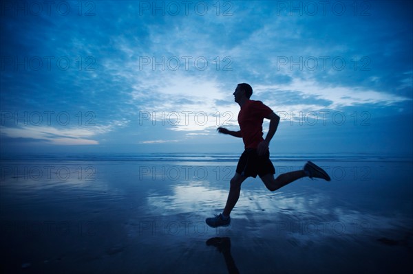 Man running along beach