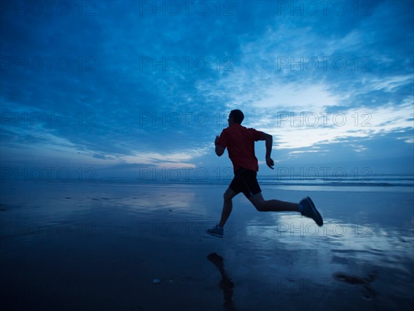 Man running along beach