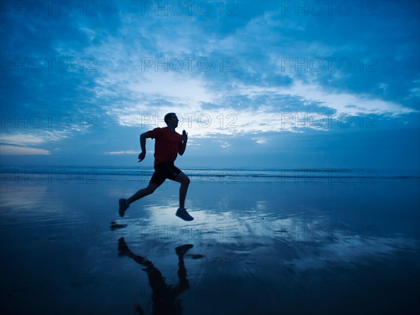 Man running along beach