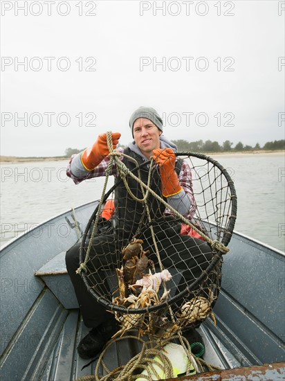 Portrait of man holding crabs in net