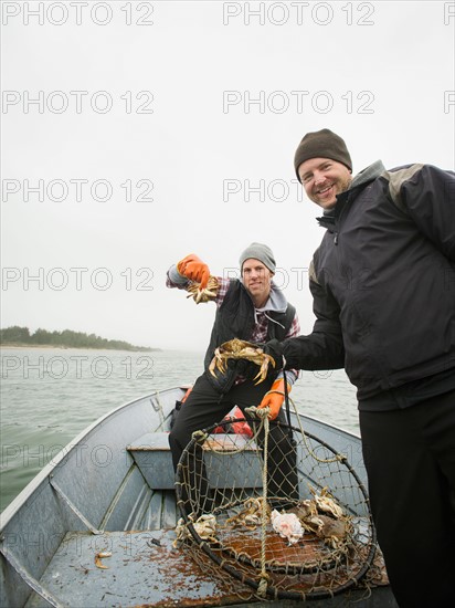 Portrait of men showing crabs