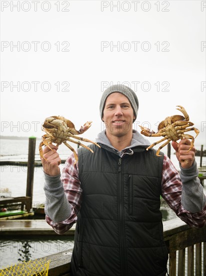 Portrait of man showing crabs