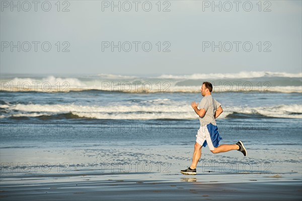 Mid adult man running on beach