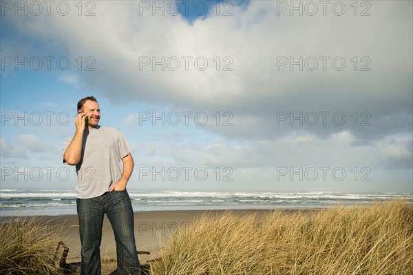 Man on phone while standing on beach