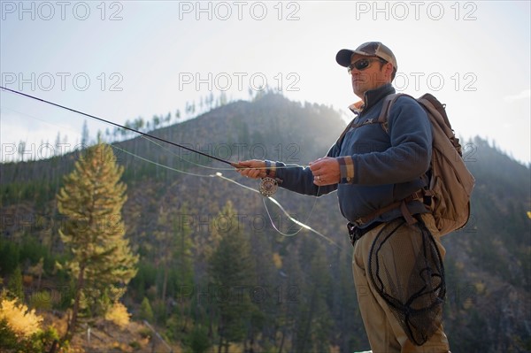 Fisherman in front of mountain