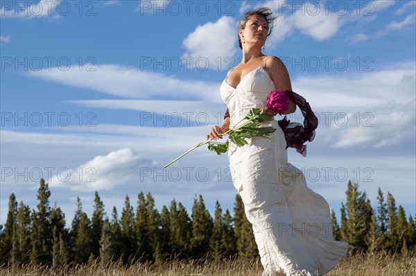 Bride standing in meadow