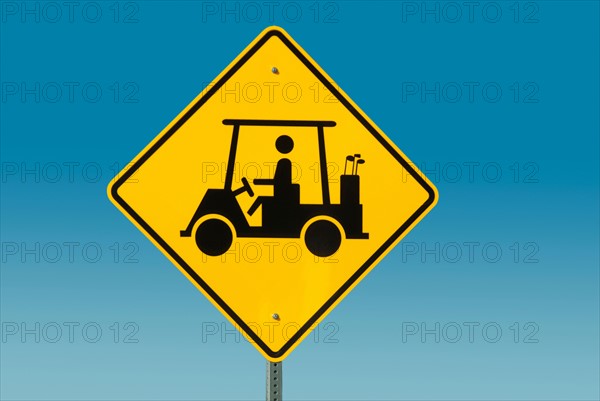 Yellow road sign depicting golf cart