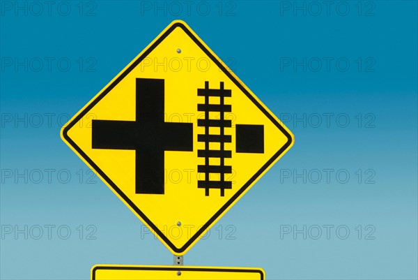 Yellow road sign depicting railroad crossing