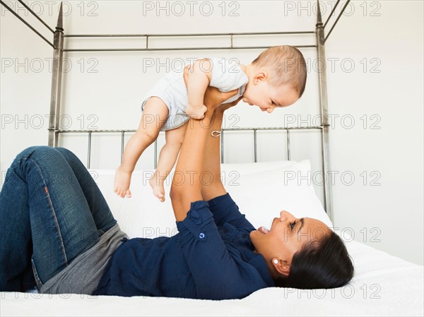 Mother lifting her son (2-5 month), playing happily