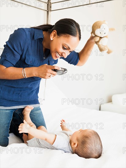 Mother playing with her son (2-5 months) taking his picture