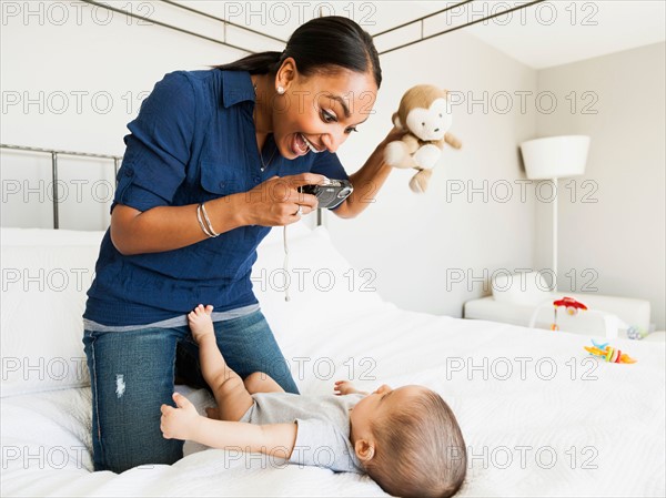 Mother playing with her son (2-5 months) taking his picture