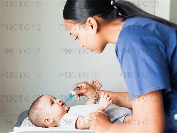 Nurse taking baby boy's (2-5 months) temperature