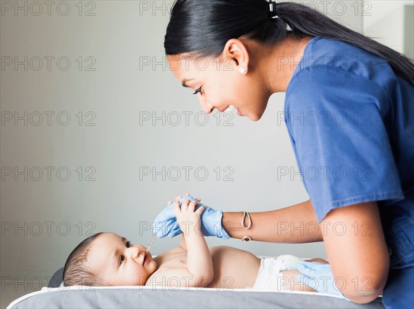 Nurse playing with ill baby boy (2-5 months)