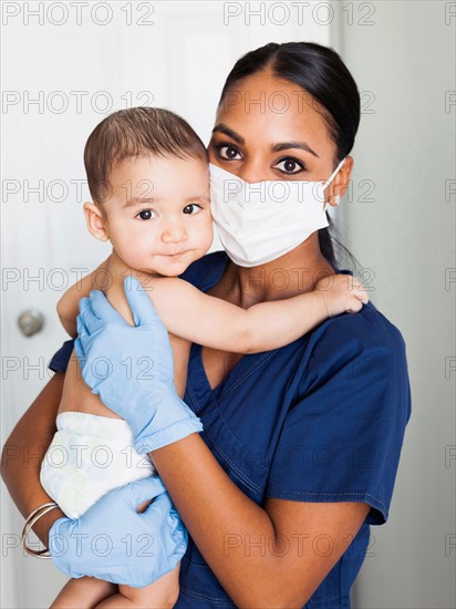 Nurse holding in arms baby boy (2-5 months)