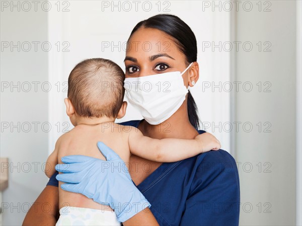 Nurse holding in arms baby boy (2-5 months)