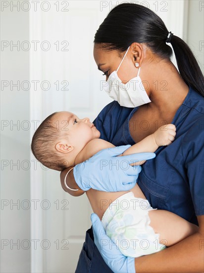 Nurse holding in arms baby boy (2-5 months)