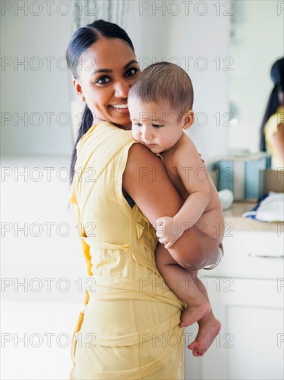 Mother preparing to give her son (2-5 months) bath