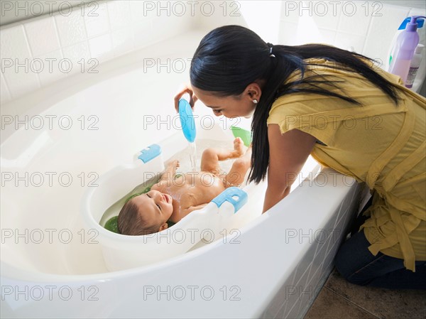 Mother giving her son (2-5 months) a bath