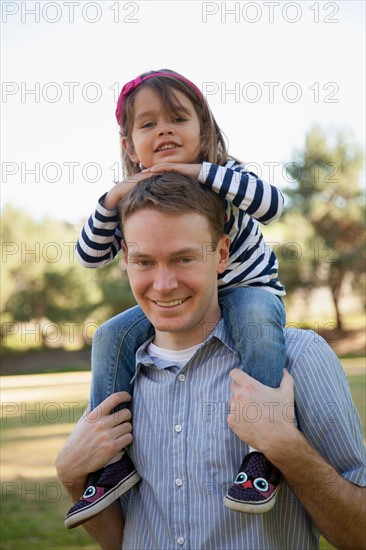 Father carrying his daughter (4-5 years) on holders