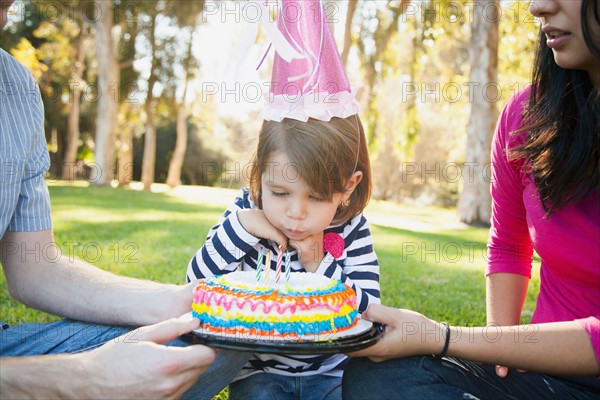 Portrait of happy family in park celebrating daughter's (4-5 years) birthday