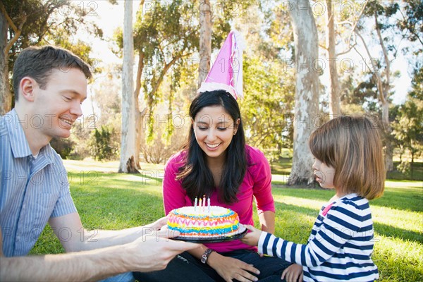 Portrait of happy family in park celebrating mother's birthday