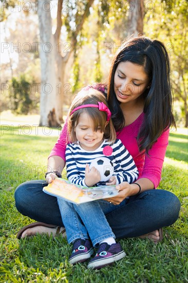 Portrait of mother and daughter (4-5) sitting in park