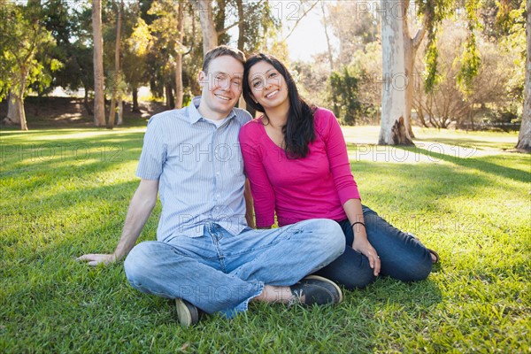 Couple sitting on grass in park