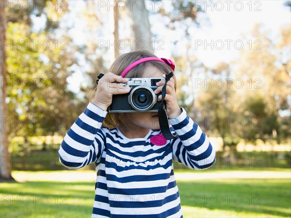 Girl (4-5) photographing in park