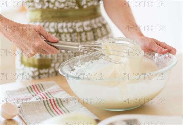 Midsection of woman whisking batter.