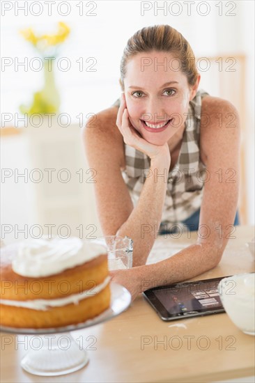 Portrait of woman using tablet pc in kitchen.