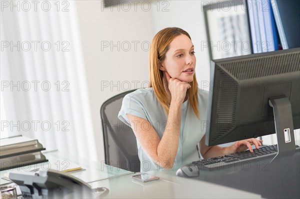 Business woman using computer in office.