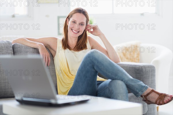 Portrait of young woman relaxing on sofa.