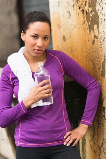 Portrait of female jogger with water bottle.