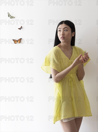 Studio shot of woman looking at butterflies.