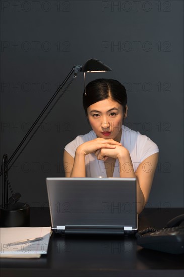 Businesswoman working on laptop at night.