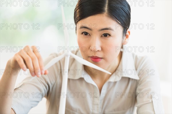 Female engineer working on model of wind turbine.