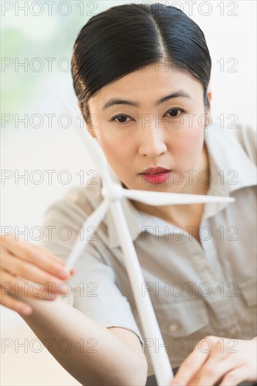 Female engineer working on model of wind turbine.