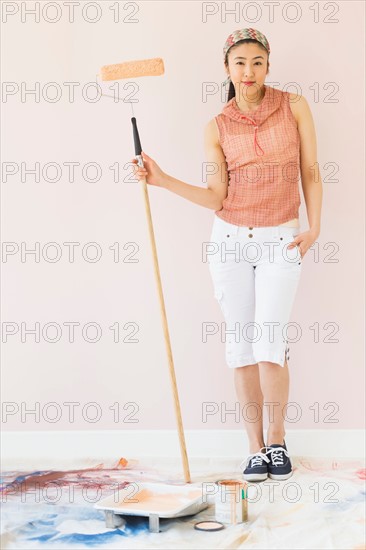 Woman holding paint roller.