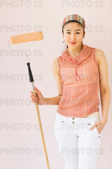 Woman holding paint roller.