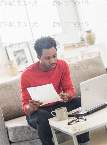 Man sitting on sofa and using laptop.