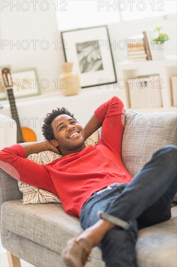 Man lying on sofa and smiling.