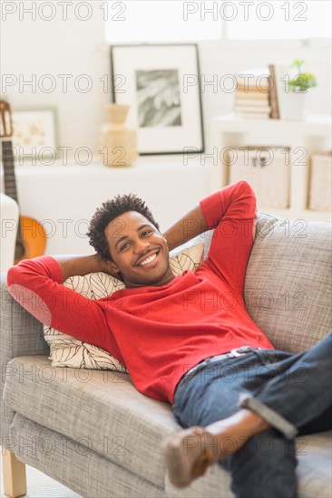 Man lying on sofa and smiling.