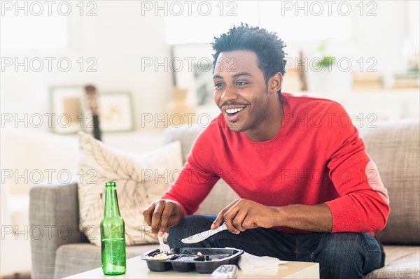 Man eating dinner and watching television.