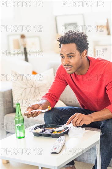 Man eating dinner and watching television.