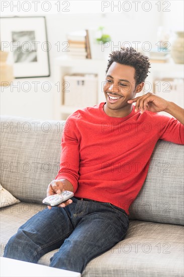 Man sitting on sofa and watching television.